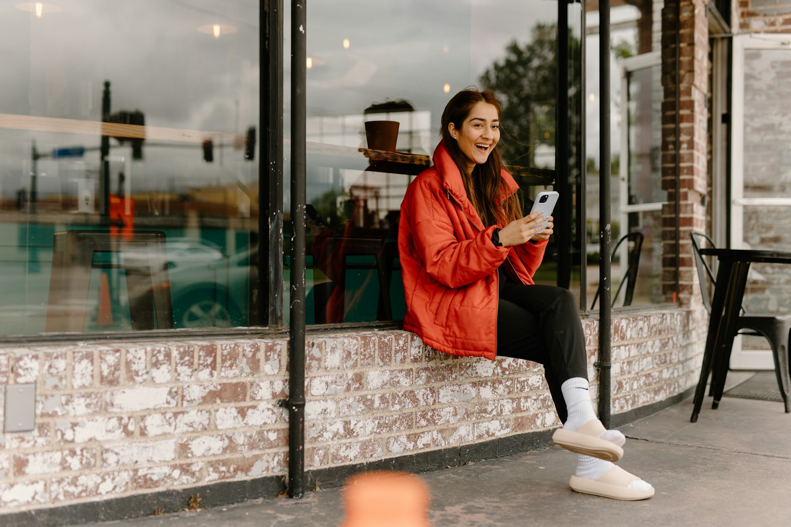 A shopper laughing at her phone outside a café - the moment an AI assistant recommends a product
